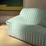 Pale green sofa against geometric wall art in the Salon Vert concept