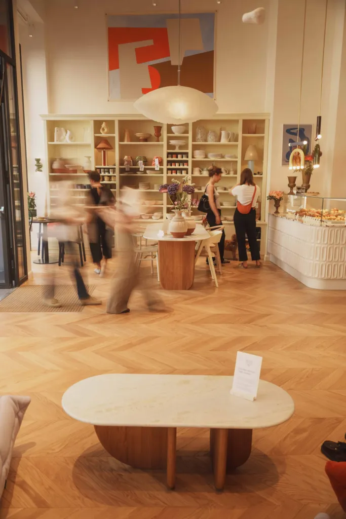 Marble table, pendant lighting and product shelves inside the Parémi café